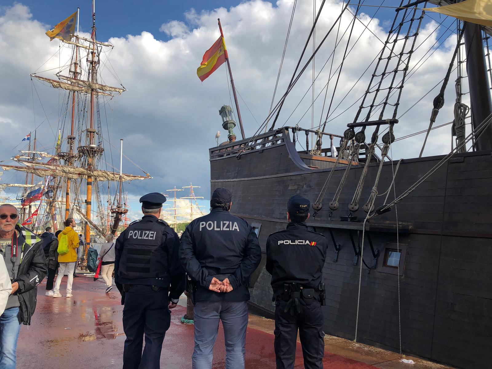 Policía Nacional con agentes de otros países uniformados frente a barca con bandera española