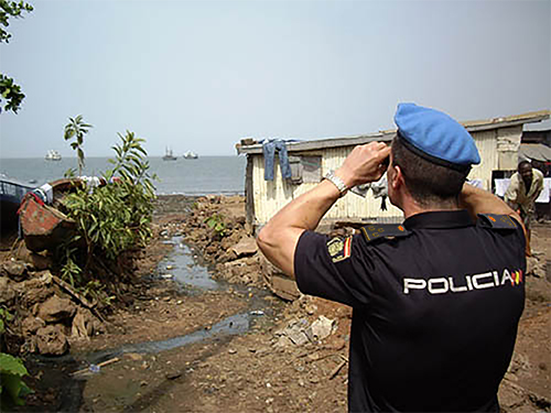Policía Nacional con prismáticos divisando el mar en Haití.