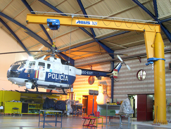 Helicóptero suspendido de una grúa en labores de mantenimiento en el hangar.