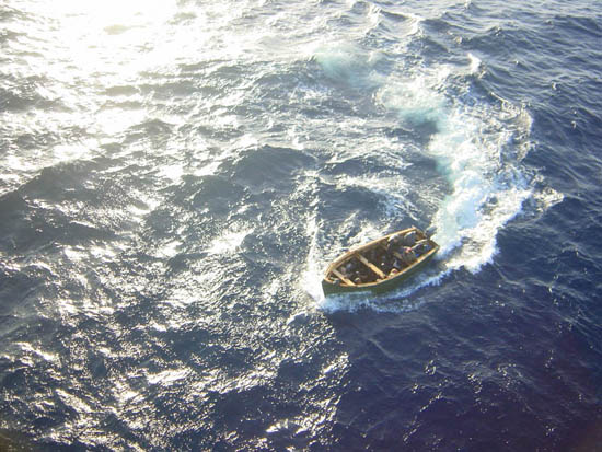 Fotografía de una embarcación con inmigrantes, desde un helicóptero de la Policía Nacional, realizando labores de apoyo en control de inmigrantes.