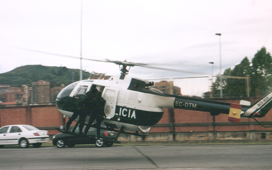 Helicóptero de Policía Nacional en fase de aterrizaje transportando a miembros de Unidades Especiales que se encuentran en el exterior del aparato.