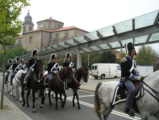 Policías Nacionales montados a caballo desfilando uniformados con el traje de gala de época.