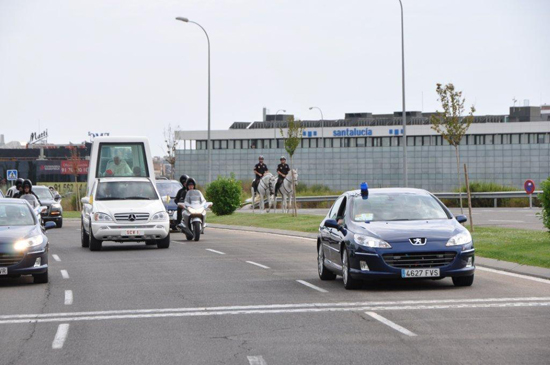 Una pareja de Policías Nacionales a caballo y un vehículo camuflado, prestando un servicio de escolta al Papa. 