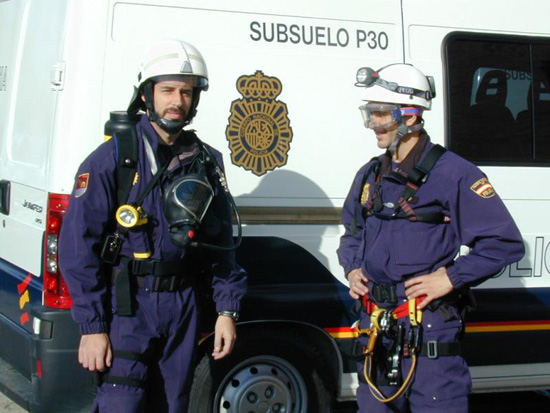 Dos Policías Nacionales de la Unidad de Subsuelo y Protección Ambiental posan equipados con el material de trabajo.