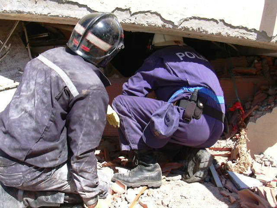 Policía Nacional de la Unidad de Subsuelo y Protección Ambiental, colabora  junto con un bombero en el derrumbe de un edificio.
