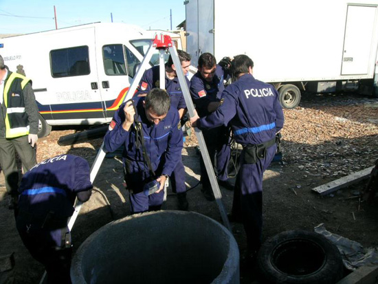 Policías Nacionales de la Unidad de Subsuelo y Protección Ambiental equipados con mono de trabajo montando una pequeña grúa