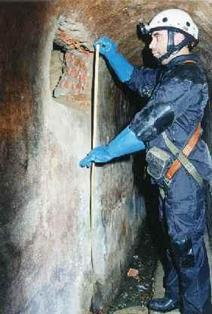 Policía Nacional de la Unidad de Subsuelo y Protección Ambienta inspecciona la rotura de la pared del alcantarillado.
