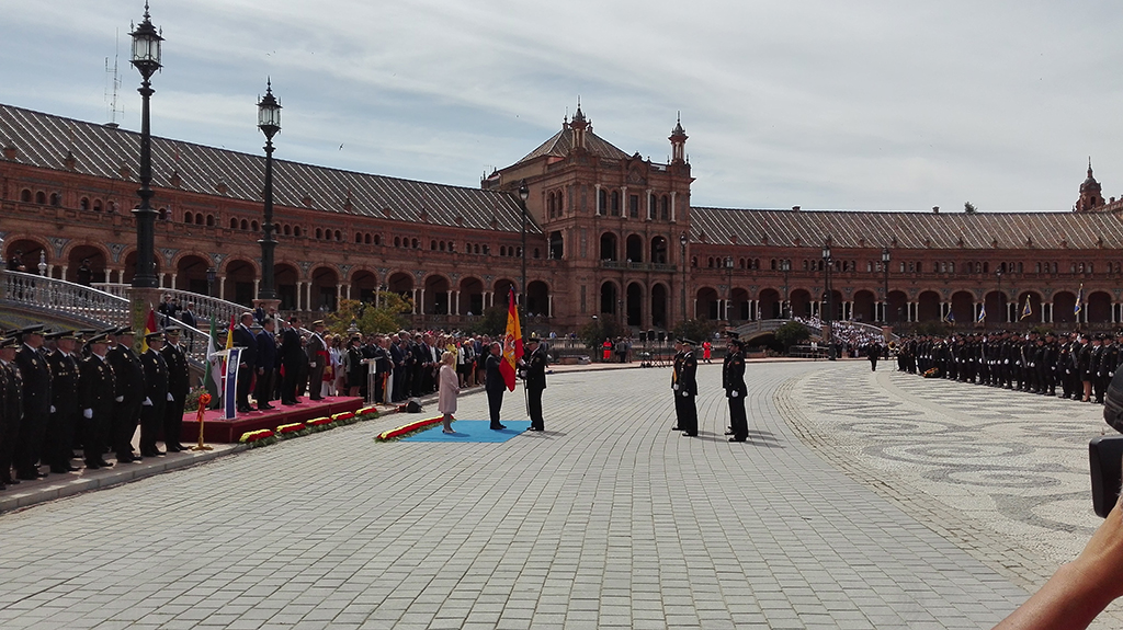 El Ministro del Interior entrega la bandera de España a un Policía Nacional en la Plaza de España (Sevilla) ante autoridades y policías en formación.