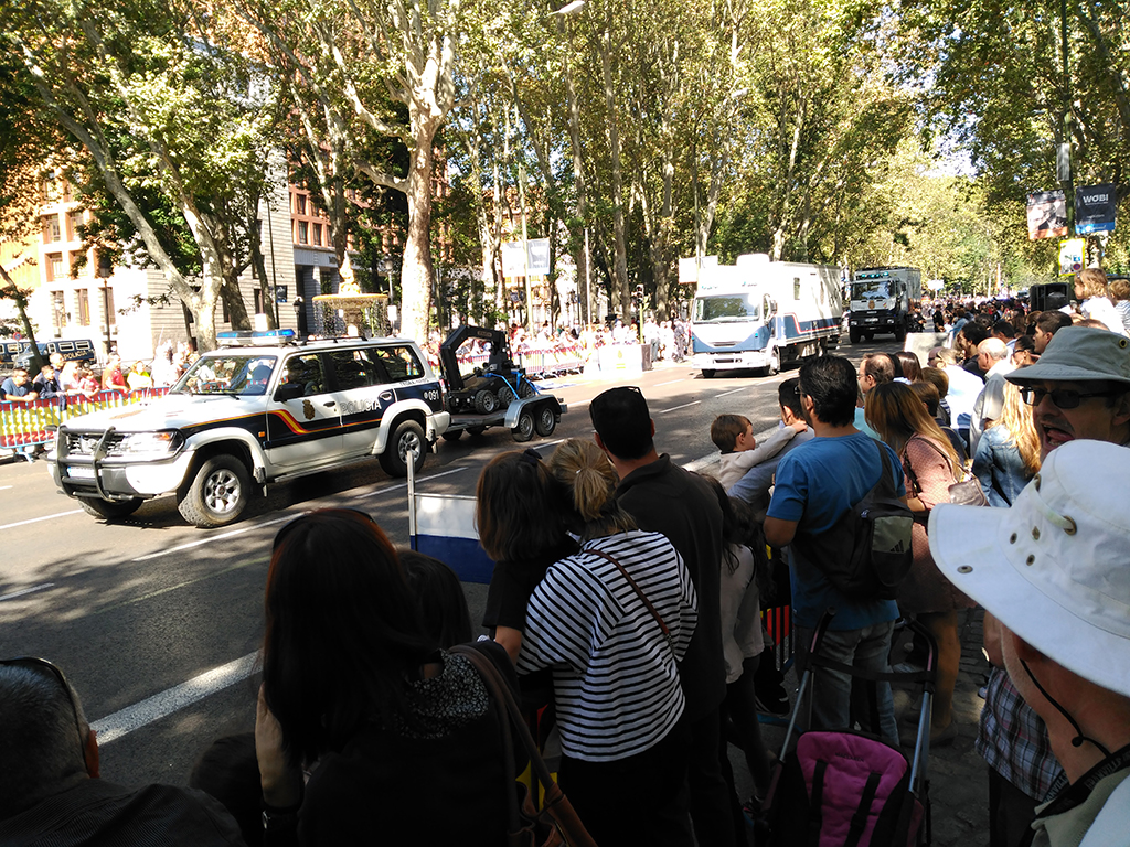 Espectadores asisten al desfile de vehículos policiales y observan el paso del robot utilizado por los TEDAX.