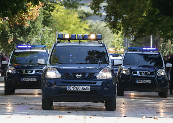 Desfile motorizado de vehículos policiales rotulados. Se ven tres todo terreno con las luces de emergencia activadas.