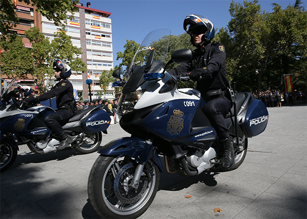 Primer plano de motocicleta rotulada pilotada por un policía nacional durante el desfile. Es una Honda Deauville 700 con equipamiento policial.
