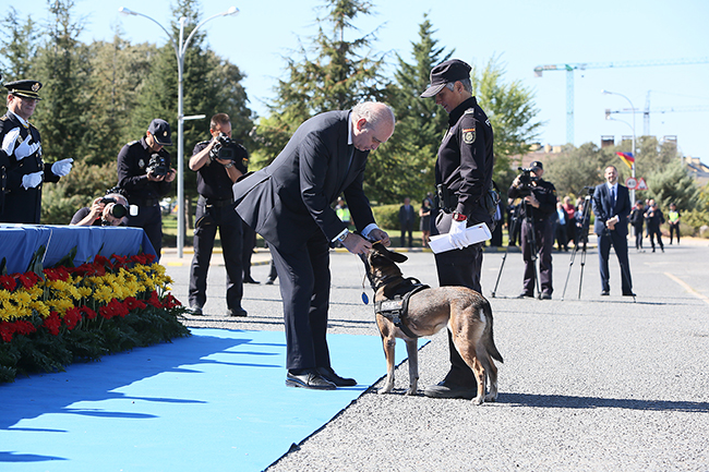 El Ministro del Interior, D. Jorge Fernández Díaz, imponiendo condecoración a perro policía que se encuentra junto a su guía.