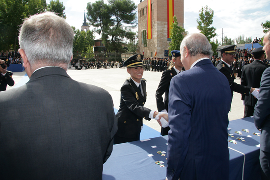El Ministro del Interior saludando a una Policía Nacional en la mesa de entrega de condecoraciones, junto con otras autoridades.