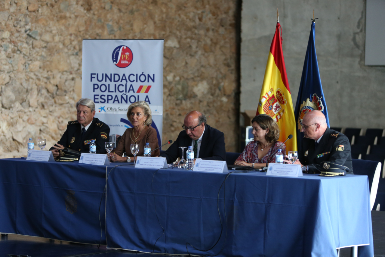 Primer plano de mesa de autoridades (tres hombres y dos mujeres), entre los que se encuentra el Director General de la Policía.
