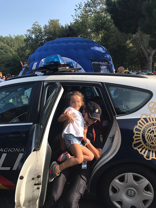 Una agente de policía con una niña en brazos dentro de un vehículo policial