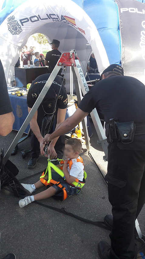 Dos policías con un niño probando equipo de la unidad de subsuelo