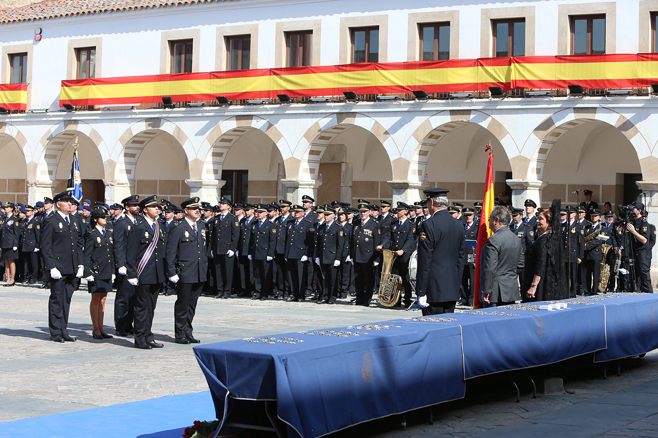 Cinco policías uniformados en posición de firme frente a diversas autoridades. 