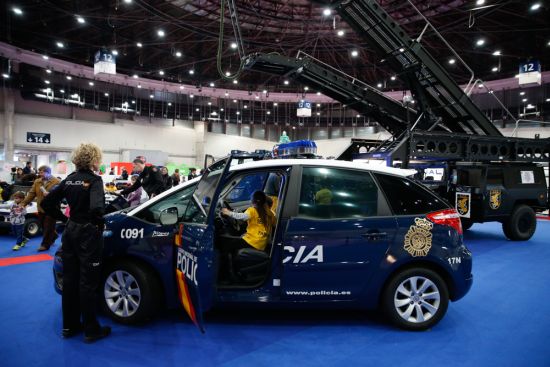 Niña dentro de un vehículo policial, Z Toyota -Prius, bajo la supervisión de una agente de policía.
