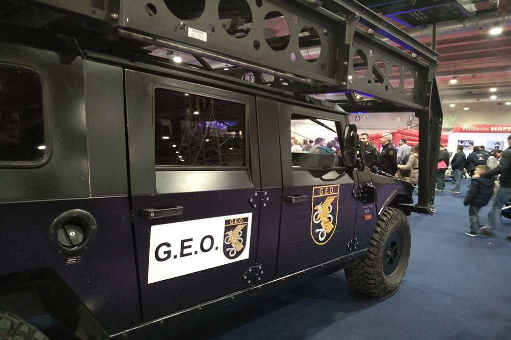 Vista lateral de un vehículo del Grupo Especial de Operaciones, en una puerta logo de la unidad y en la otra, cartel con logo y siglas G.E.O.