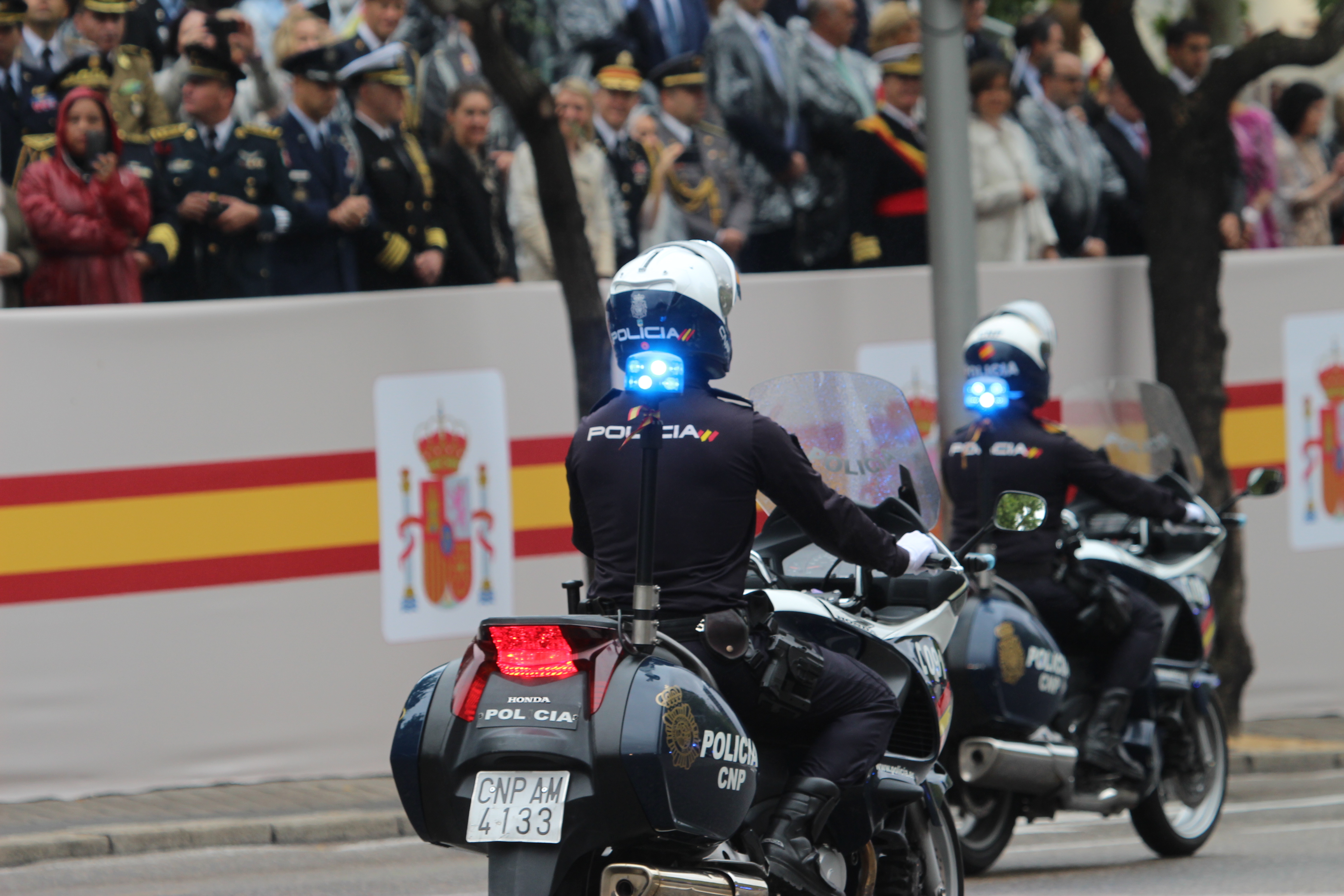 Vista de espaldas de dos agentes de policía desfilando en motocicleta