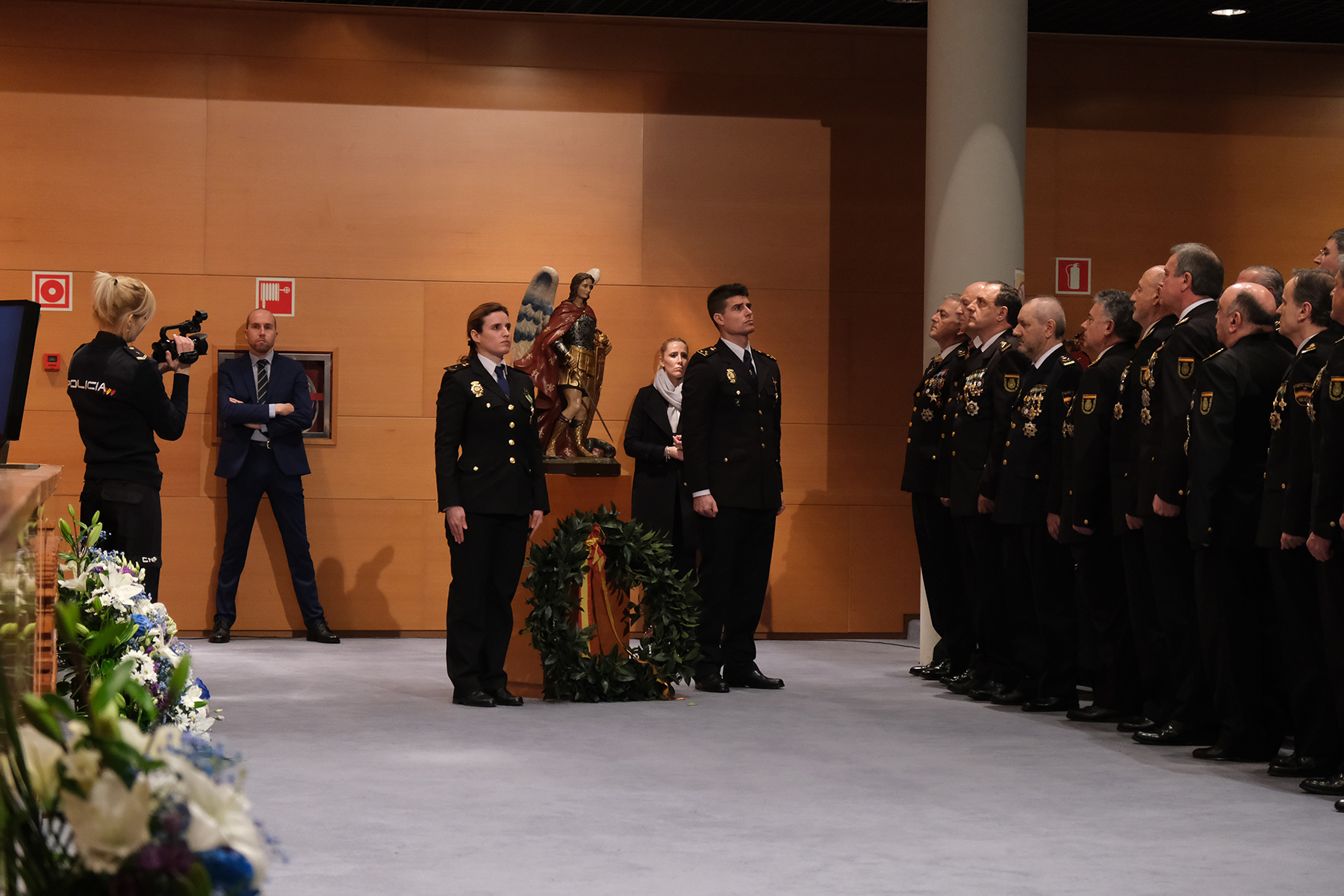 Ofrenda de una corona, por parte de dos policías nacionales (hombre y mujer), a los Santos Ángeles Custodios, patrón de la Policía Nacional.