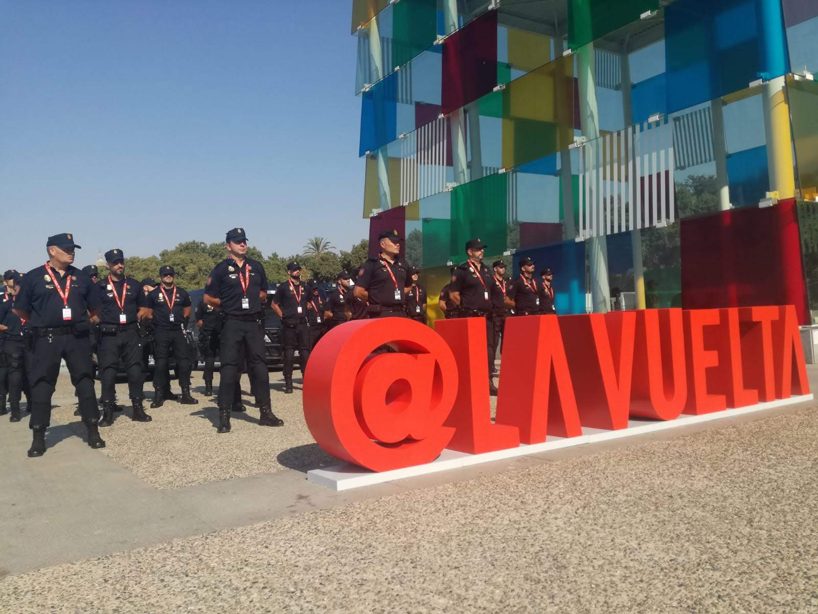Varios agentes de la Policía Nacional posando junto al logotipo @LAVUELTA