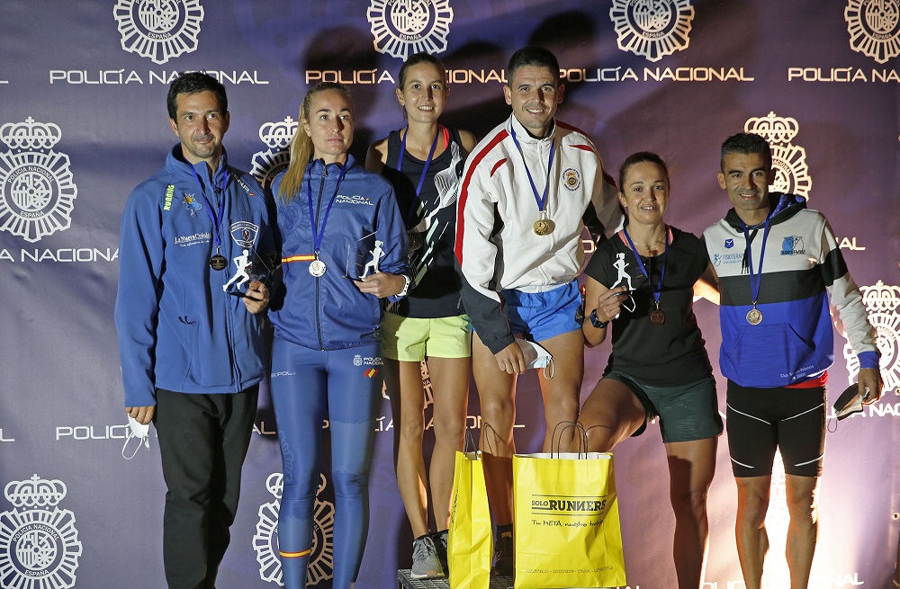 Seis participantes de la carrera nocturna posan con las medallas obtenidas.