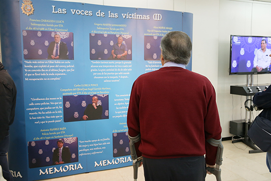 Visitante de la exposición observa el panel Las voces de las víctimas, en el cual se pueden leer los testimonios de familiares y víctimas de atentados