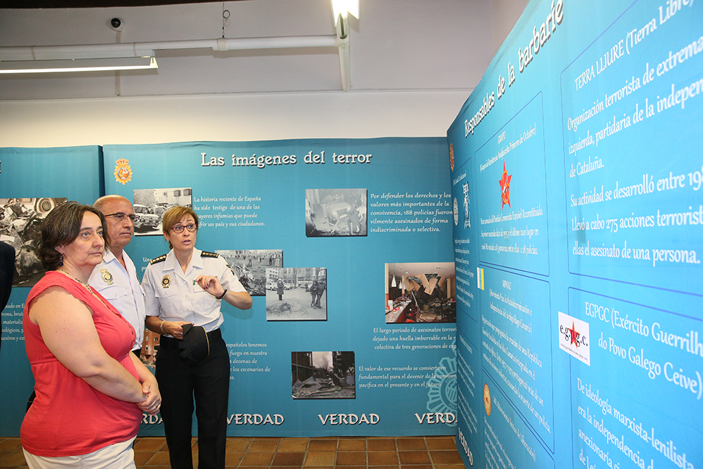 La Alcaldesa de San Lorenzo del Escorial, el D.A.O. y la Subdirectora del Gabinete Técnico de la P.N., observando paneles de la exposición.