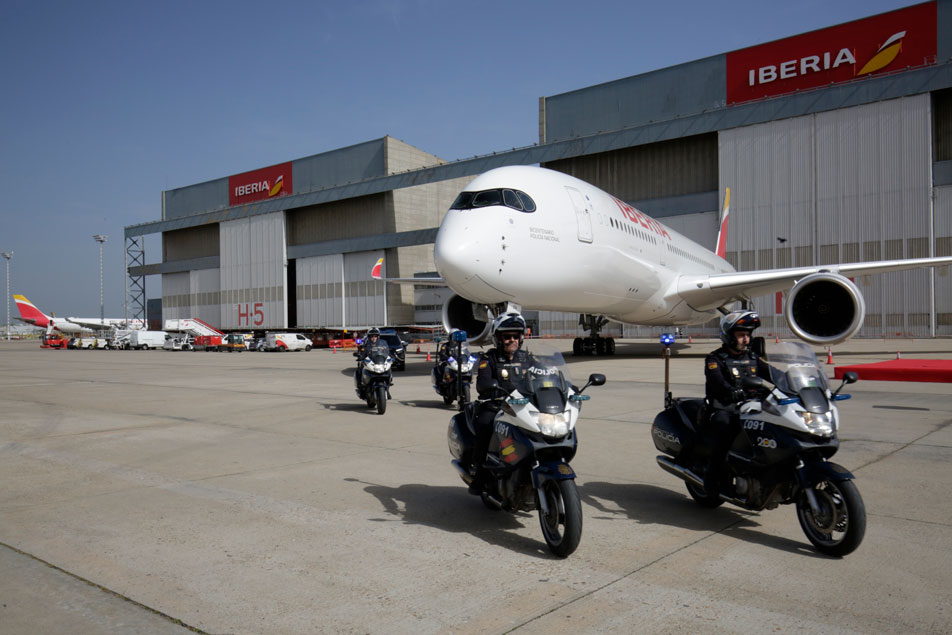 Avión escoltado por policías, de la unidad móvil, cerca del hangar de Iberia.