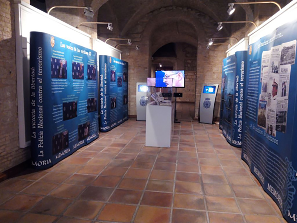 imagen de la sala de exposiciones donde se pueden observar varios paneles, vitrinas, televisiones con videos, y kioscos táctiles interactivos.
