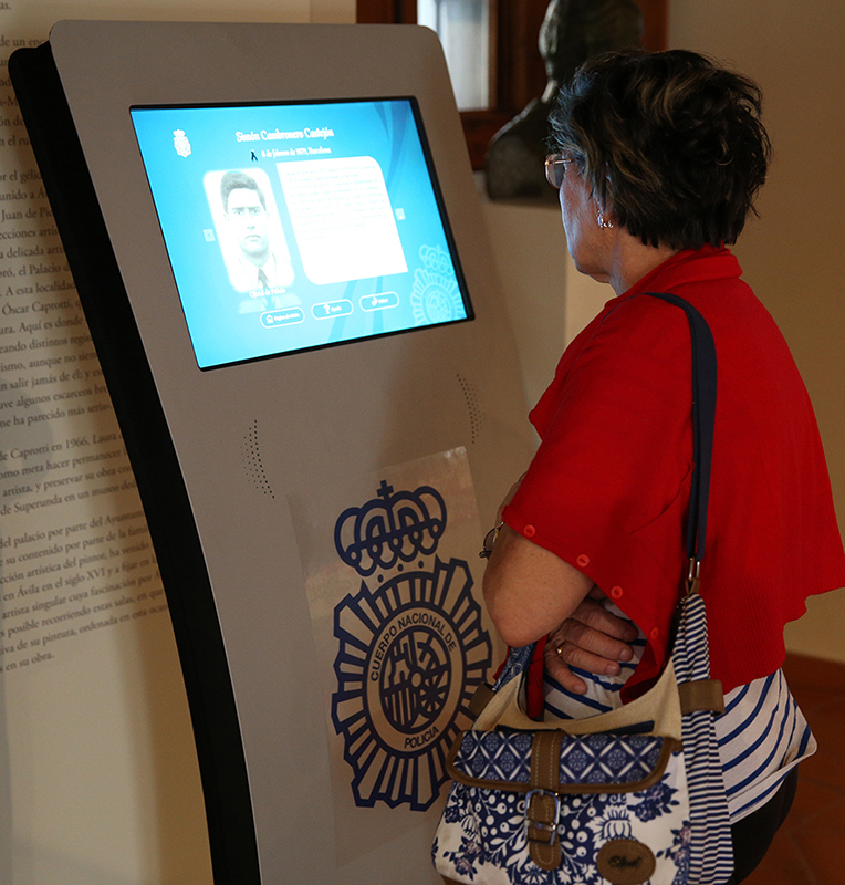 Una visitante interactuando con un kiosco táctil de la exposición.