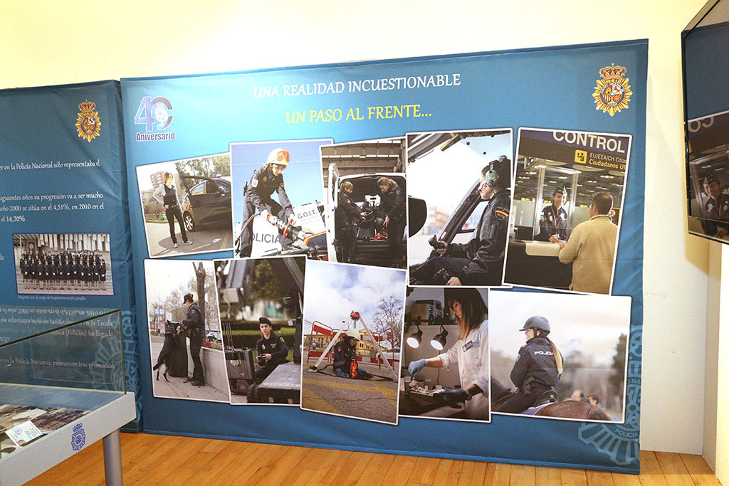 En primer plano cartel explicativo con imágenes de mujeres policías desarrollando su actividad en distintas unidades de la Policía Nacional.