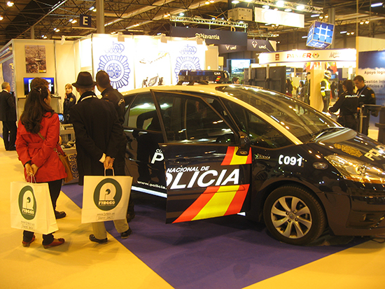 Visitantes de la feria viendo vehículo policial rotulado, Citroen C4 Picasso, expuesto en el stand.