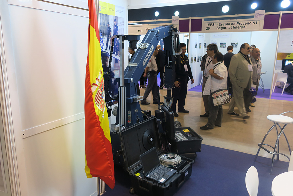 Bandera de España, robot para desactivar explosivos y equipo para el manejo del robot.