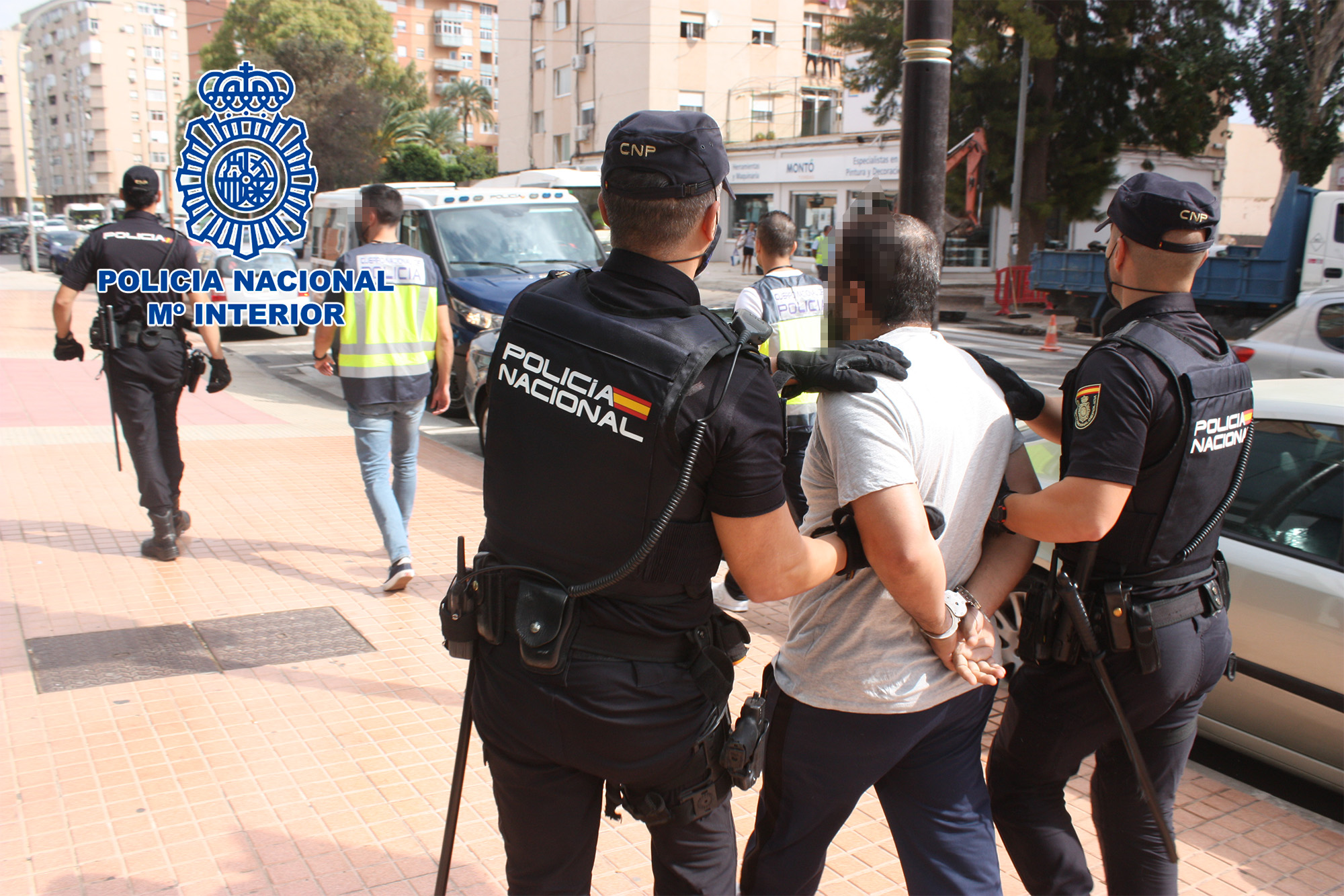Traslado del detenido por dos agentes de Policía Nacional