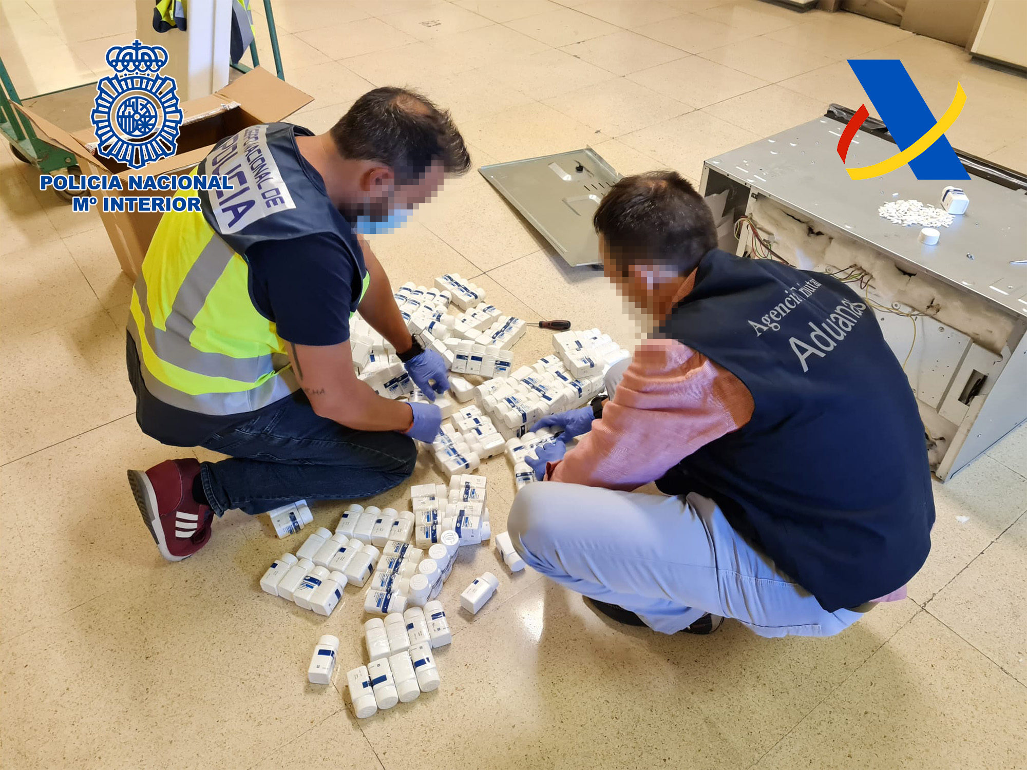 Dos agents de Policia Nacional i de l'Agència Tributària amb pots de pastilles intervenudes