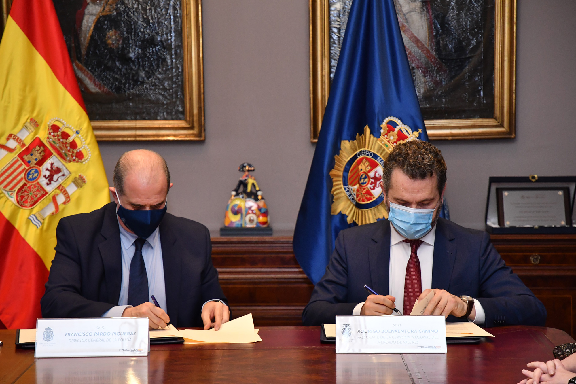 El director general de la Policía y el presidente de la CNMV firmando el Convenio
