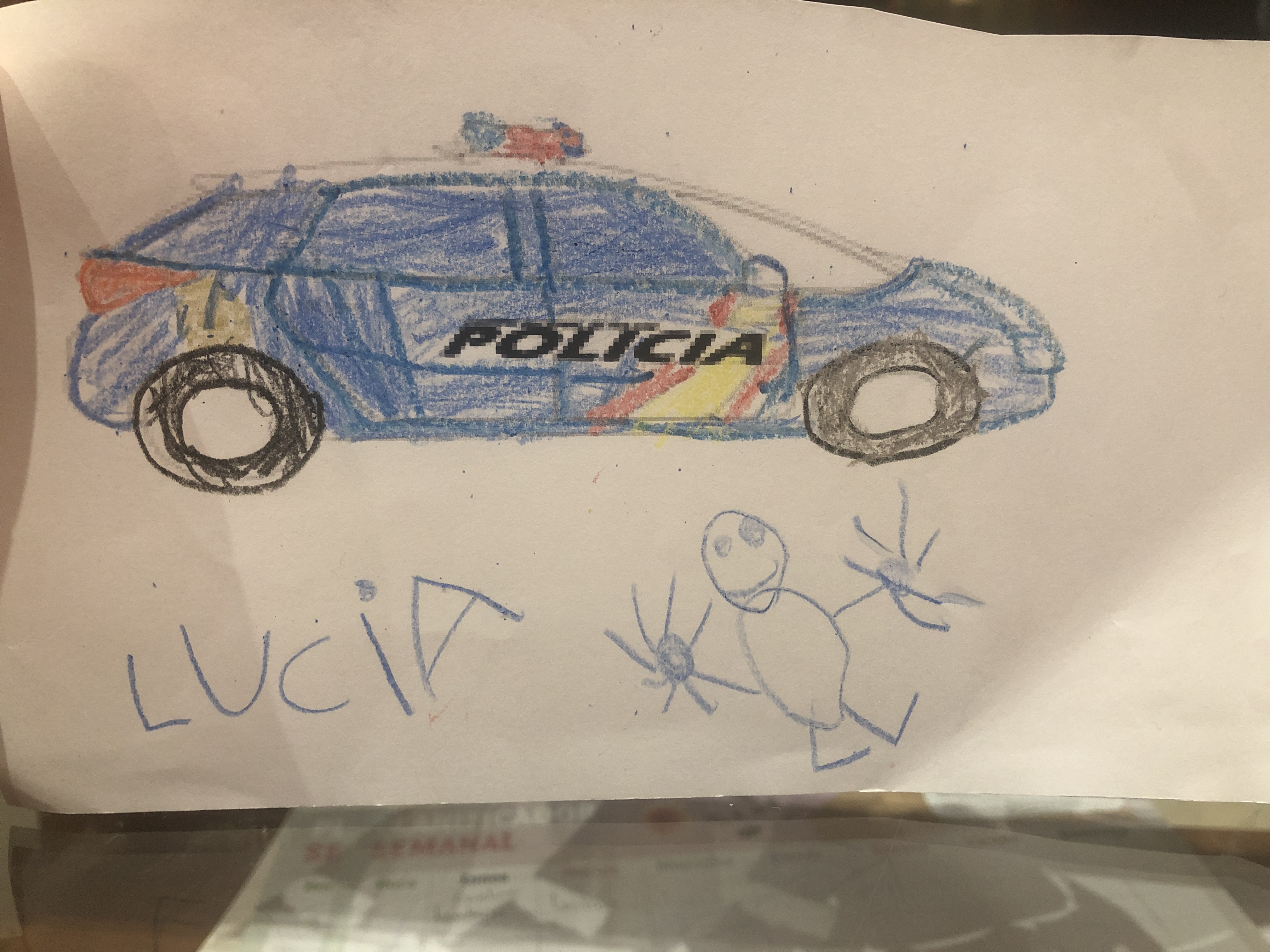 Coche de la policía y muñeco en el suelo junto a la firma de Lucía