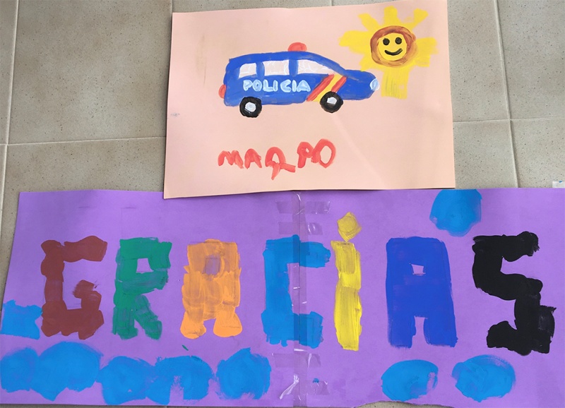 Dibujo de un coche de policía acompañado de una pancarta con la palabra gracias dibujado el letras de colores.